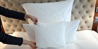 In einem Hotelzimmer wird ein Bett hergerichtet (Foto: picture alliance/dpa | Bernd Weißbrod)