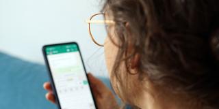 Jemand benutzt WhatsApp auf einem Smartphone (Foto: picture alliance/dpa | Weronika Peneshko)