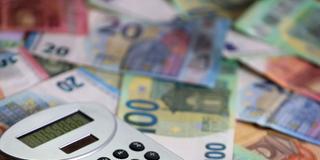 Illustration: Ein Taschenrechner liegt auf verschiedenen Euro-Banknoten (Foto: picture alliance/dpa | Karl-Josef Hildenbrand)