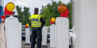 Ein Bundespolizist steht an einer Grenzkontrolle. (Foto: picture alliance/dpa | Harald Tittel)