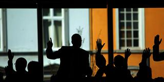 Schattenriss von Menschen, die mit den Händen abstimmen (Foto: picture alliance / dpa | Fredrik von Erichsen)