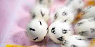 Lotto-Kugeln liegen auf einem Lottoschein (Foto: picture alliance/dpa | Tom Weller)