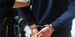Ein Polizist führt einen Mann mit Handschellen ab (Foto: picture alliance/dpa | Christoph Reichwein)