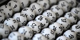 Lottokugeln liegen in einem Koffer. (Foto: picture alliance/dpa | Arne Dedert)