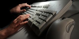 Symbolbild: Eine Frau tippt auf einer Computertastatur (Foto: dpa/Jochen Lübke)