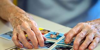Eine Seniorin legt beim Memory spielen Kartenpaare zusammen (Foto: picture alliance/dpa | Sven Hoppe)