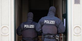 Polizeikräfte betreten bei einer Razzia ein Gebäude (Foto: picture alliance/dpa | Sebastian Kahnert)