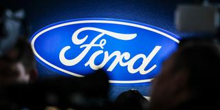 Ein beleuchtetes Firmenschild des Autobauers Ford leuchtet am Rande einer Betriebsversammlung (Foto: picture alliance/dpa | Christoph Reichwein)