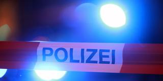 Blaulichter leuchten hinter einem Absperrband der Polizei (Foto: picture alliance/dpa | David Young)