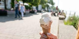 Eine Frau hält ihr Eis in der Sommersonne (Foto: picture alliance/dpa | Silas Stein)