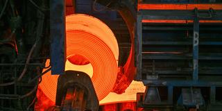 Glühender Flachstahl wird zu einem Coil im Warmwalzwerk aufgewickelt. (Foto: picture alliance/dpa | Patrick Pleul)