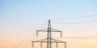 Strommast mit Überlandleitungen bei Sonnenaufgang (Foto: picture alliance/dpa | Silas Stein)