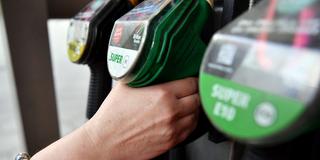 Eine Hand greift nach einer Zapfpistole an der Tankstelle (Foto: picture alliance/dpa | Paul Zinken)