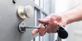 Ein Justizbeamter steckt einen Schlüssel in das Schloss einer Haftzelle. (Foto: picture alliance/dpa | Michael Matthey)