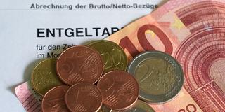 Euro- und Centmünzen liegen auf einem 10-Euro-Schein und bilden den kommneden Mindestlohn von 13,90 Euro. (Foto: picture alliance/dpa | Marcus Brandt)