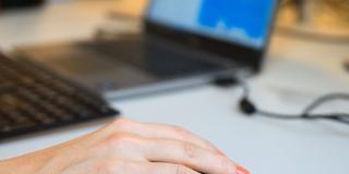 Eine Frau bedient eine Computermaus an einem Schreibtisch (Foto: picture alliance/dpa | Julian Stratenschulte)