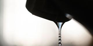 Ein tropfender Wasserhahn im Gegenlicht (Foto: picture alliance/dpa | Marijan Murat)