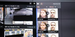 Symbolbild. Live-Videobilder sowie das Bild einer fiktiven Person auf einer Videowand. KI-Software zur Gesichtserkennung. (Foto: picture alliance/dpa | Boris Roessler)