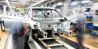 Mitarbeiter der Autoproduktion scheinen in der Bewegungsunschärfe zu verschwinden (Foto: picture alliance/dpa | Julian Stratenschulte)