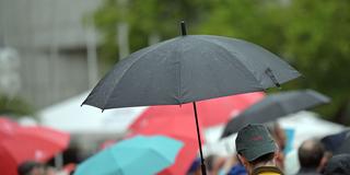 Passanten mit Regenschirmen in einer Fußgängerzone (Foto: picture alliance/dpa | Michael Brandt)
