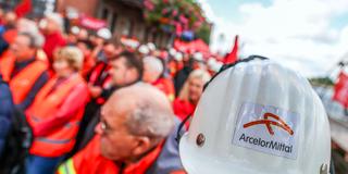 Logo des weltgößten Stahwerkbetreibers Arcelor Mittal auf dem Helm eines Mitarbeiters (Foto: picture alliance/dpa | Christoph Reichwein)