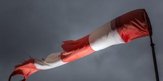 Ein Windsack zeigt starken Seitenwind an (Foto: Michael Reichel/dpa)