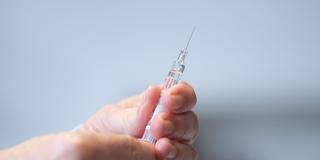 Ein Arzt hält eine Fertigspritze mit einem Impfstoff in den Händen. (Foto: picture alliance/dpa | Sebastian Kahnert)