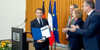 Emmanuel Macron hält die Urkunde zur Ehrendoktorwürde in der Hand (Foto: SR)