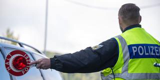 Ein Bundespolizist hält einen PKW an einer Kontrollstelle an (Foto: picture alliance/dpa | Harald Tittel)