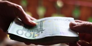 Eine jüngere und eine ältere Person halten ein Bündel mit Euroscheinen in der Hand. (Foto: picture alliance/dpa | Karl-Josef Hildenbrand)