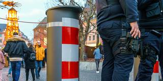 Sicherheitspersonal steht an einem LKW-Poller vor einem Weihnachtsmarkt (Foto: picture alliance/dpa | Andreas Arnold)