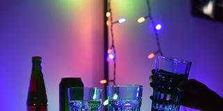 Symbolbild: jemand greift nach einem Glas während einer Party (Foto: picture alliance/dpa | Christian Thiele)