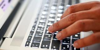 Jemand tippt auf einer Computertastatur (Foto: picture alliance/dpa | Uli Deck)