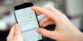 Auf dem Display eines iPhones sieht man einen WhatsApp Chatverlauf. (Foto: picture alliance / ZB | Britta Pedersen)