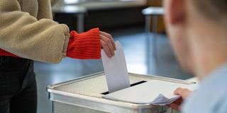 Eine Frau steckt ihren Stimmzettel in eine Wahlurne (Foto: picture alliance/dpa | Helena Dolderer)