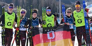 Linn Kazmaier (2.v.l.) mit Guide Florian (l), Johnna Recktenwald (3.v.l.) mit Guide Emily Weiss (3.v.r) und Leonie Walter (2.v.r.) mit Guide Christian Krasman (r., alle Deutschland) im Ziel bei den Paralympics im Para Biathlon Sprint Frauen sehbehindert im Tesero Cross-Country Skiing Stadium.  (Foto: picture alliance/dpa | Martin Schutt)