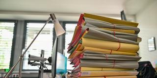 Ein Stapel Aktenordner auf einem Schreibtisch. (Foto: picture alliance/dpa | Patrick Pleul)