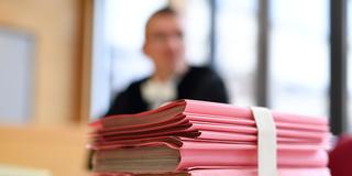 Ein Stapel an Akten liegt auf dem Tisch im Gerichtssaal. (Foto: picture alliance / Uwe Anspach/dpa)
