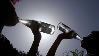 Zwei Personen trinken aus einer Flasche Wasser (Foto: Karl-Josef Hildenbrand/dpa)