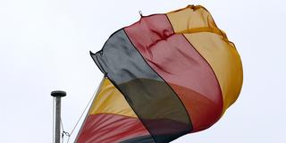 Eine Deutschlandflagge dreht sich bei stürmischem Wetter an einem Fahnenmast. (Foto: picture alliance / Karl-Josef Hildenbrand/dpa )