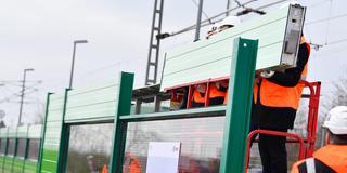 Montage eines Elements einer Schallschutzwand neben einer Bahntrasse (Foto: picture alliance / Uwe Anspach / dpa)