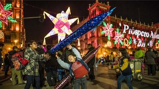 Kinder spielen in Mexiko-Stadt mit Luftballons, im Hintergrund eine Pinata-Lichterkette (Foto: picture alliance / Germán Espinosa/El Universal via ZUMA Wire/dpa | Germán Espinosa)