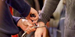 Jemand schließt angelegte Handschellen auf (Foto: picture alliance / Roland Weihrauch / dpa)