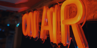 orangenes Leuchtschild "On Air" (Foto: unsplash/Alan Findlay)
