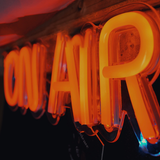 orangenes Leuchtschild "On Air" (Foto: unsplash/Alan Findlay)