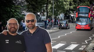 Zwei Männer halten sich im Arm. Dahinter ist eine Straße mit einem roten Londoner Bus zu sehen. (Foto: IMAGO / Eibner)