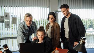 Das Polizeiteam sitzt bzw. steht vor einem Schreibtisch und schaut gemeinsam auf einen Computer. (Foto: Manuela Meyer (SR))