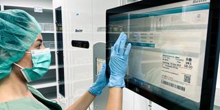 Eine Mitarbeiterin der UKS-Klinikapotheke kontrolliert einen Auftrag am Medikamenten-Verpackungsautomaten (Foto: UKS / Herrmann)