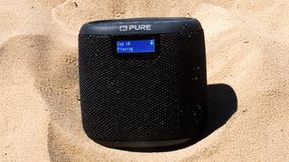 Der Lautsprecher liegt im Sand am Meer. (Foto: PURE)