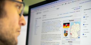 Eine Person liest die Wikipedia Seite für Saarland (Foto: Sebastian Knöbber)